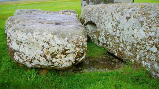 Image of the examined altar stone. It weighs six tons and is half buried under two other stones.