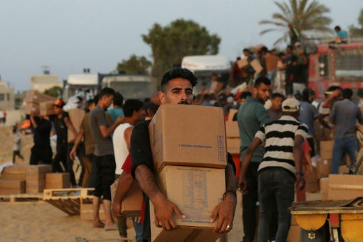 Quando le spedizioni di aiuti iniziarono ad arrivare attraverso il molo fuori dalla Striscia di Gaza, i camion furono saccheggiati.