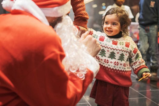 Kisha, 2 år, träffade jultomten för första gången på julfesten för nyanlända och etablerade svenskar.