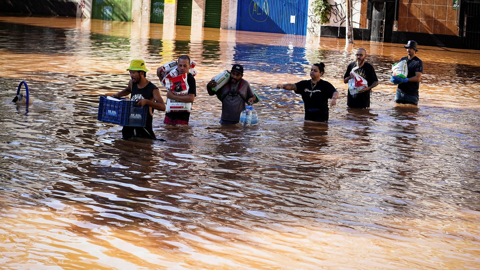 Människor vadar genom översvämningar i Porto Alegre i södra Brasilien.