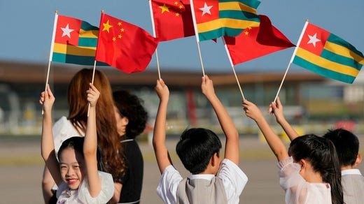 Chinese children wave the flags of China and Togo before Togo's President Faure Gnassingbe lands at Beijing airport. Gnassingbe is in Beijing to participate in a summit between Africa and China.