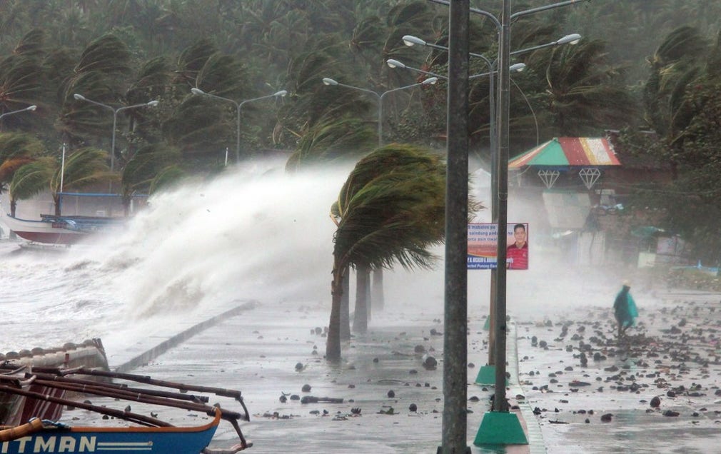 Höga vågor slår mot Legaspi i Albay-provinsen när tyfonen först slog till mot Filippinerna på fredagen.