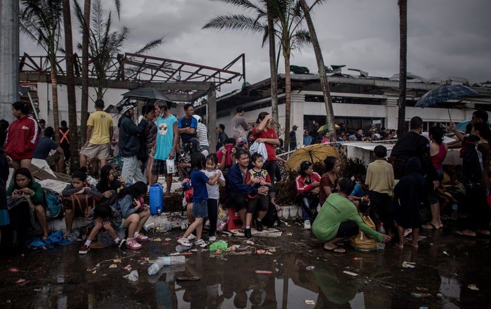 Överlevande i Tacloban väntar vid flygplatsen på att evakueras från staden på tisdagen.