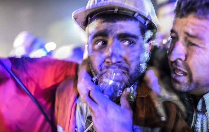 En gruvarbetare, räddad ur den raserade gruvan, får syrgashjälp.