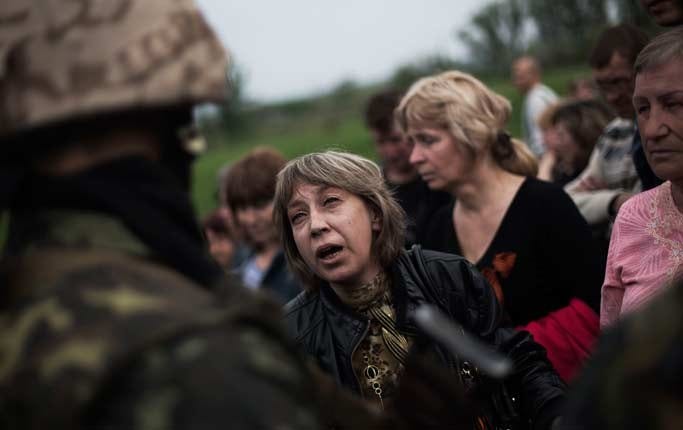 En prorysk kvinna i samtal med en ukrainsk soldat tidigt på fredagen i byn Andreevka, tio kilometer söder om Slovjansk, då regeringsstyrkor intog positioner runt staden.