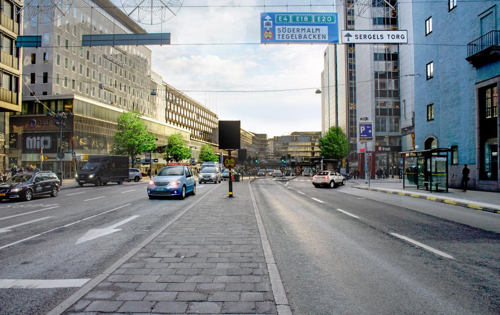 Stockholms city i dag. En del av Stockholms city domineras i dag helt av stora kontorsklotsar och mycket asfalt för bilkörning. Gående gör sitt bästa för att undvika en gata som Sveavägen.