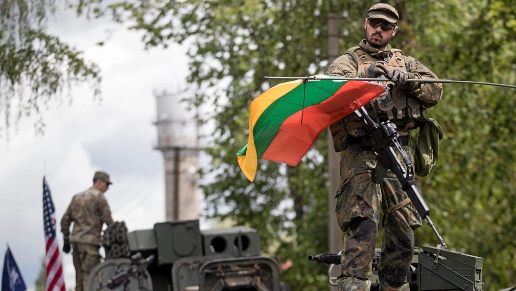 En tysk soldat höjer den litauiska flaggan under en Natoövning i Kapuski, 16 mil norr om huvudstaden Vilnius.