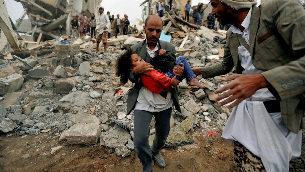 En man bär Buthaina från det raserade huset. Bombdådet i Sanaa dödade hela hennes familj.