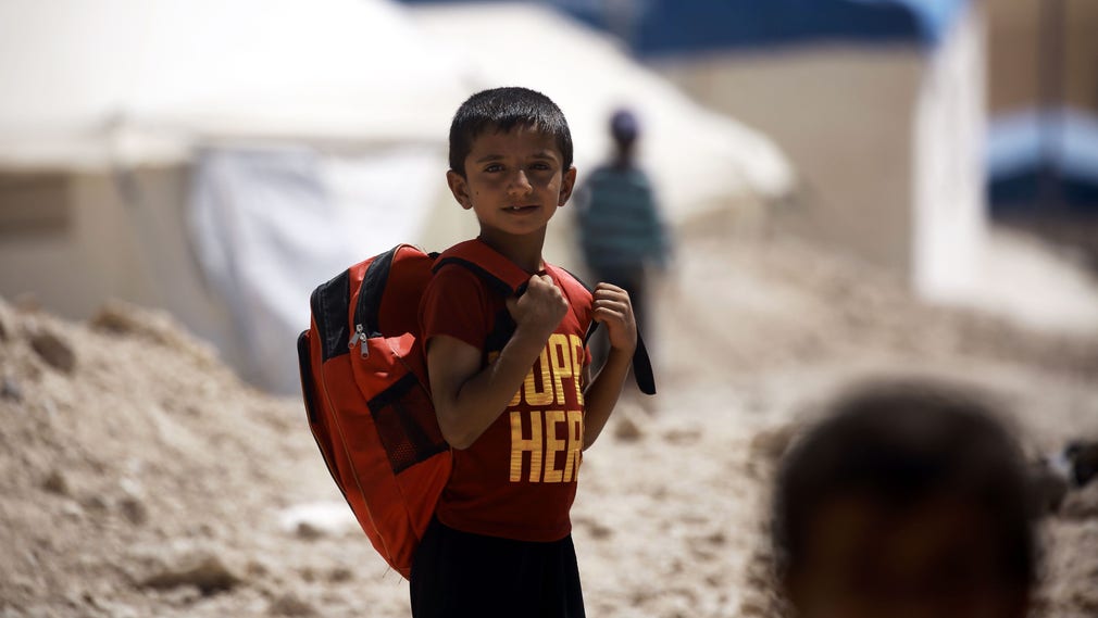 En pojke som flytt från IS-hållna Raqqa i Syrien är på väg till skolan i ett flyktingläger i Ain Issa.