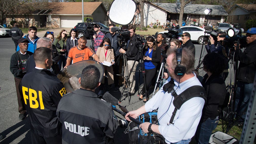 Pressen uppvaktar polisen vid en av de båda platser i Austin där måndagens explosioner inträffade.