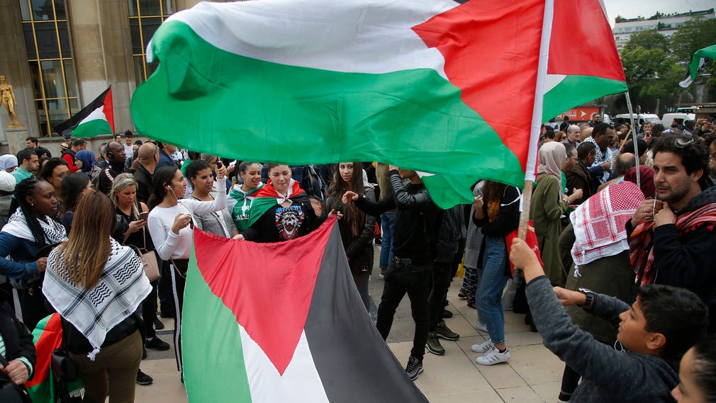 Demonstranter i Paris viftar med palestinska flaggor och fördömer Israels våld i Gaza. Hamas sade på onsdagen att de flrsta som dödats vid gränsen var medlemmar i organisationen.