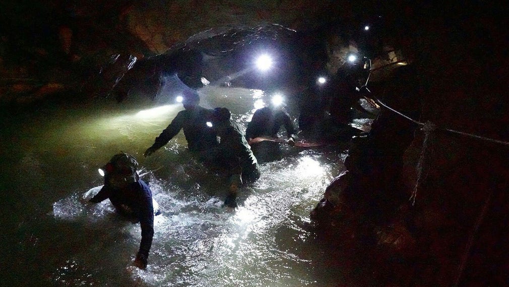 Thailändska Navy Seals tar sig fram i den översvämmade grottan Tham Luang.