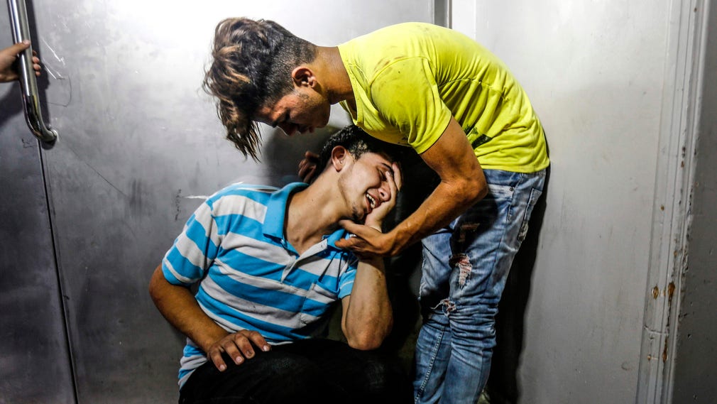 Palestinska ungdomar vid ett bårhus i Gaza efter att två tonåringar dödats.