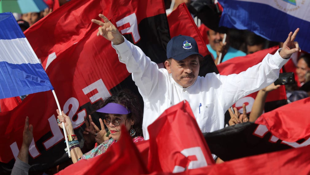 Daniel Ortega med sin fru, vicepresident Rosario Murillo, vinkar till anhängare under torsdagens firande.