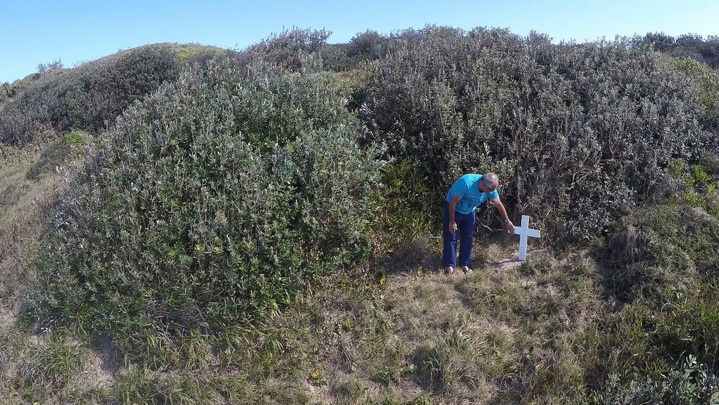 En man besöker minnesplatsen för sin mördade styvdotter, en aboriginsk kvinna, vid Ten Mile Beach på australiska östkusten i augusti 2016. Myndigheternas ovilja att lagföra de misstänkta väckte debatt om rasism mot aboriginer. Arkivbild.