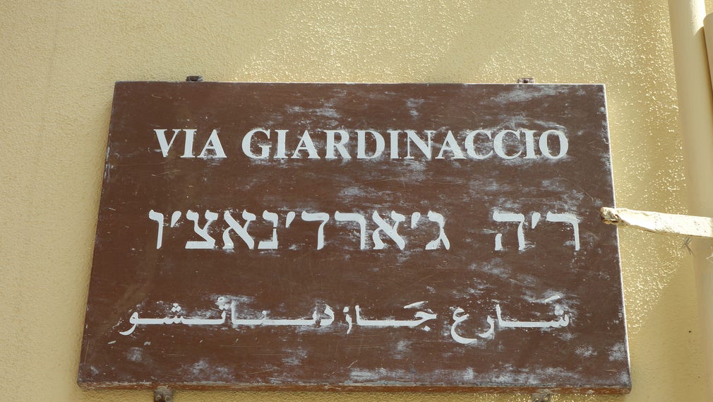 Gatuskylt i Palermo på italienska, hebreiska och arabiska.