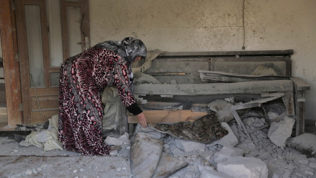 Efter USA:s insats i byn Barisha i Idlib förstördes flera hem. En kvinna ser över skadorna.