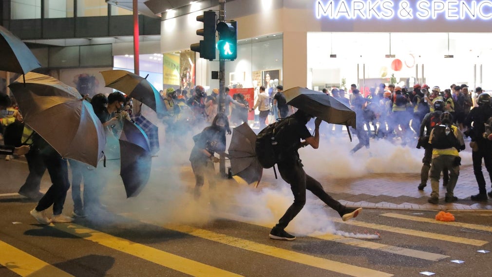 Demonstranter sparkar i väg tårgasbehållare under sammandrabbningar med polisen på söndagen 10 november.