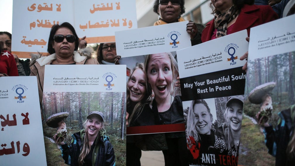 Marockanska kvinnor bär på bilder av de två mördade kvinnorna vid en ljusmanifestation utanför danska ambassaden i december förra året.