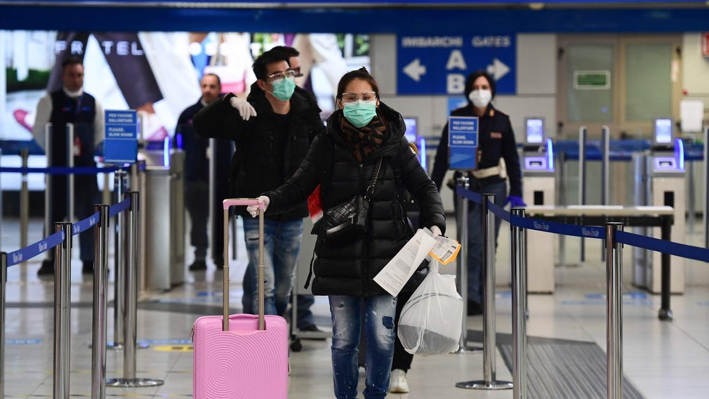 Passagerare med munskydd på Milanos flygplats under onsdagen.