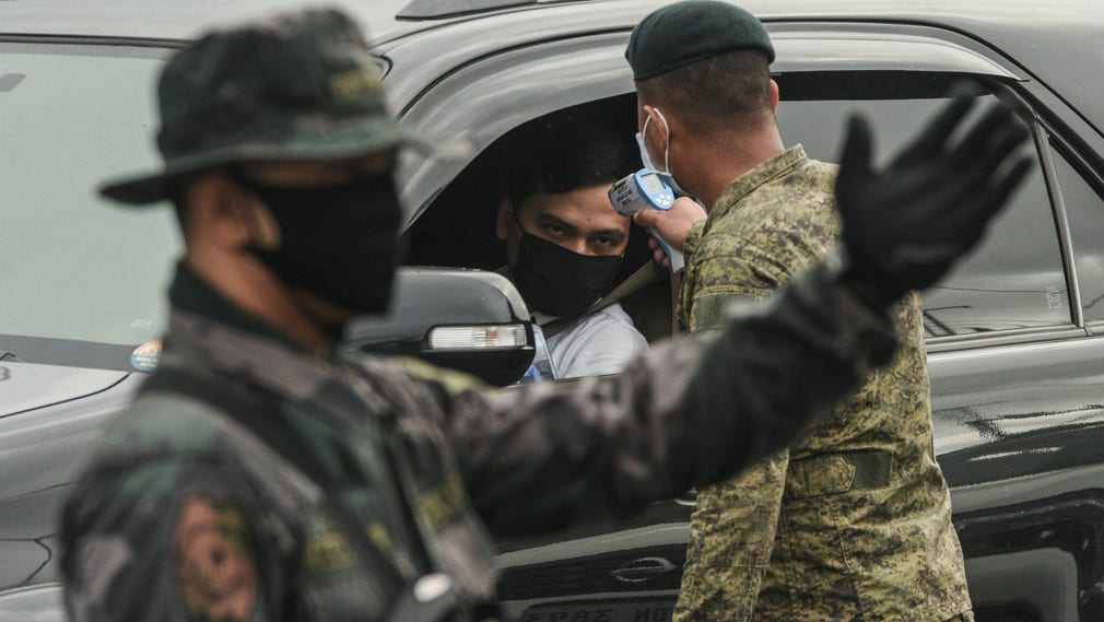 En soldat tar tempen på en bilist i Manilla.