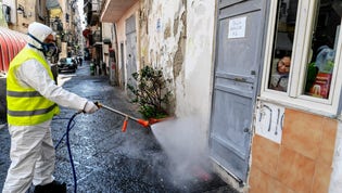 Renhållningsarbetare desinficerar gatorna i Neapel i södra Italien, där man fruktar att antalet covid-19-fall snart ökar.